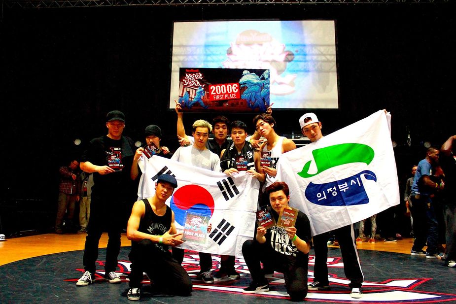 B-Boy Krops who is on the bottom right is holding two 1st place trophies