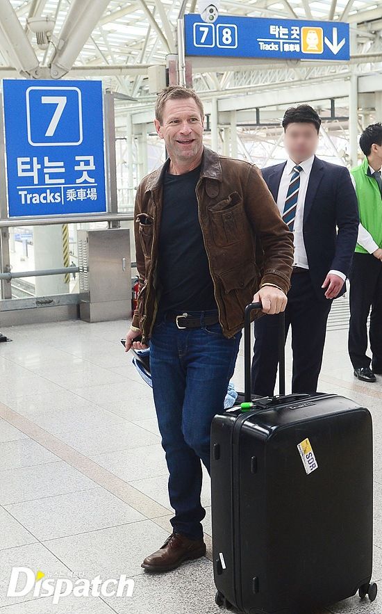 Aaron Eckhart smiling at the media who greeted him at the train station / Image source: Dispatch