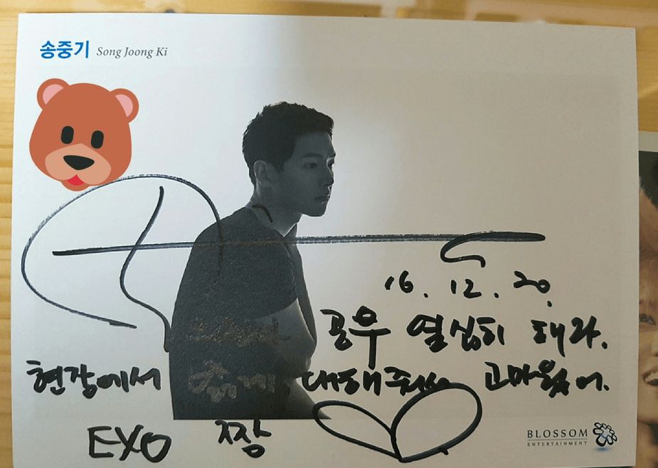 Actor Song Joong Ki signed on a staff member's card that he was a fan of EXO too. 