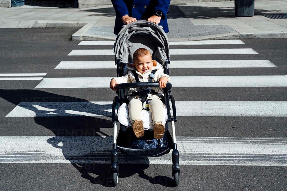 father-with-smiling-baby-in-baby-stroller-crossing-road-in-city-PGF00155